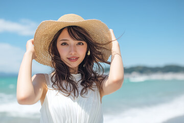 Smiling Japanese woman with straw hat on tropical beach

