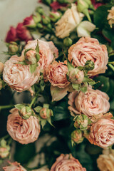 bouquet features delicate pink and cream roses, their lush petals and budding flowers. this floral arrangement adds elegance to a lively significant event outdoors. vertical. close up.
