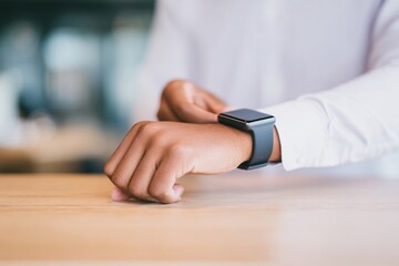 Stylish individual checking the time on a sleek smartwatch in a modern setting