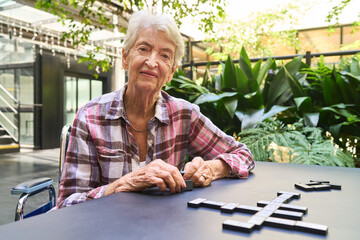 Senior woman playing board game outdoors at a rehabilitation facility
