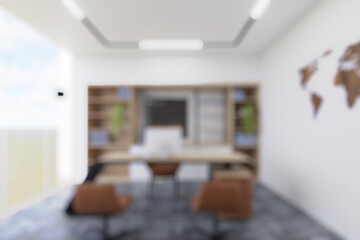 Blurred office interior with natural wooden elements and green plants, creating a calm and collaborative workspace.