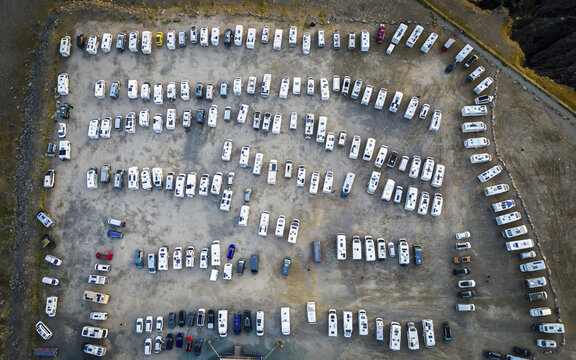 Aerial view of a large array of RVs parked in the parking lot at Nordkapp, their white roofs contrasting against the dark ground, Nordkapp, Finnmark, Norway.