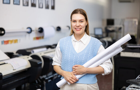 Portrait of positive woman with plotter roll paper in her hands