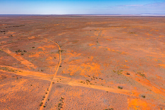 intersecting lines of outback tracks in barren landscape with Lake Gairdner on horizon