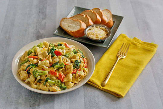 tortellini primavera with broccoli, carrot, and tomato in a parmesan garlic cream sauce