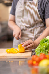 Chef Slicing Yellow Bell Pepper on Cutting Board