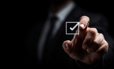 Businessman touching a virtual screen with a checkmark icon 