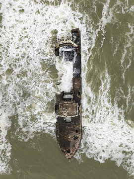 Aerial view of the Zeila shipwreck, a rusting skeleton embraced by the tumultuous, foamy waves of the Skeleton Coast, Zeila shipwreck, Erongo Region, Namibia.