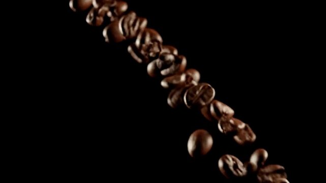 Coffee beans falling in slow motion against a dark background in a visually appealing arrangement