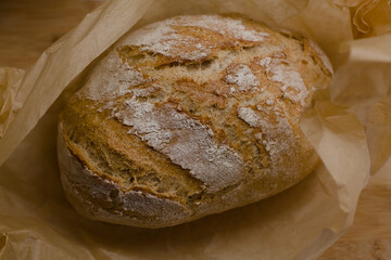 Freshly baked bread unwrapped on a baking paper
