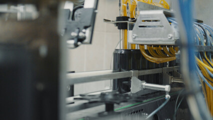 Conveyor belt transporting dark cans being filled by an automated machine in a beverage production factory, showcasing the efficiency of modern industrial processes