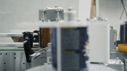 Modern labeling machine automatically applying labels to bottles on a conveyor belt in a beverage factory, ensuring efficient and precise product packaging