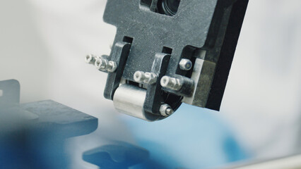 Close up of a robotic arm applying pressure with a roller during a manufacturing process, highlighting automation and precision in modern industry