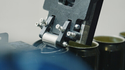 Automated industrial machine sealing aluminum cans in a beverage or food production line, showcasing advanced technology and automation in modern manufacturing