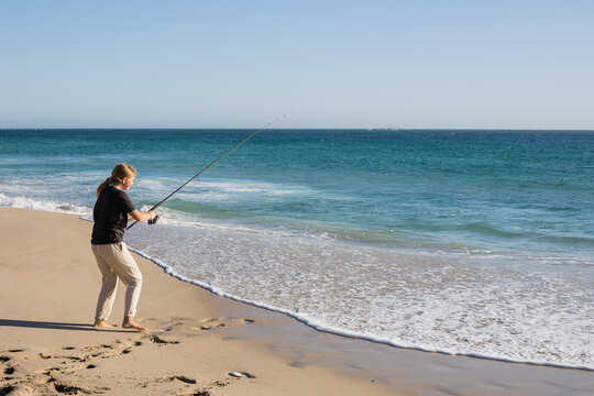 Girl fishing on remote australian beach