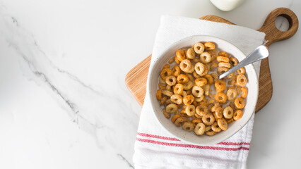 A bowl of round crispy cereal with milk. Healthy breakfast. Copy space
