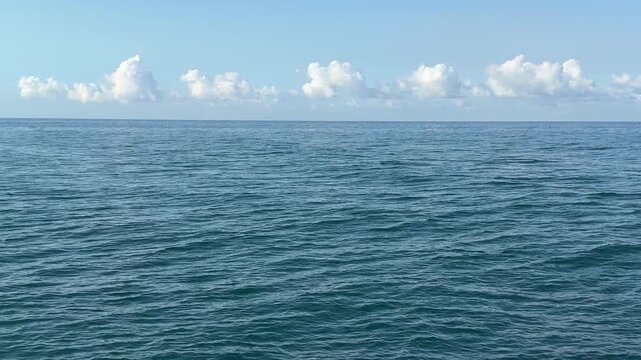 Blue sea waves, clouds and blue sky.