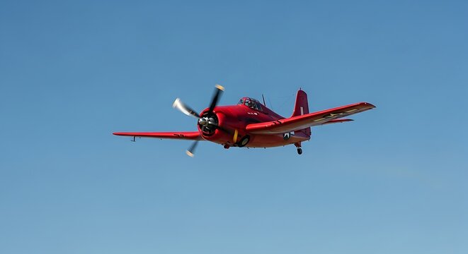 Crimson Grumman F4F Wildcat gracefully soars against the vast blue canvas of the sky