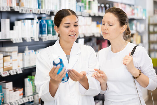 Woman pharmacist gives advice to woman customer what cosmetic product to buy in pharmacy
