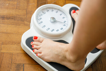 Woman checking weight on scale at home
