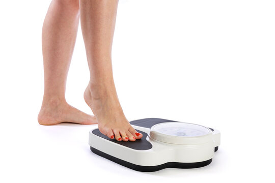 Woman stepping onto bath scale on white background