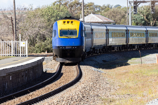 Looking along train tracks to a XPT train and station