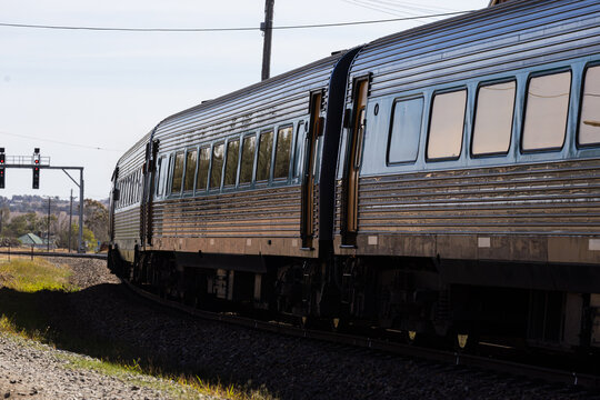 Looking along train and carriages to signals at a rural train station