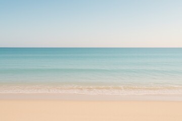 Fototapeta premium Serene Horizon A tranquil view of a sandy beach meeting the gentle waves of the ocean under a clear sky