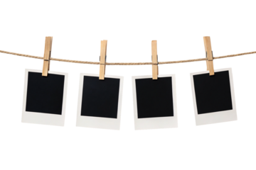 Four blank polaroid photos hanging on rope with wooden clothespins against white background, isolated on a transparent background
