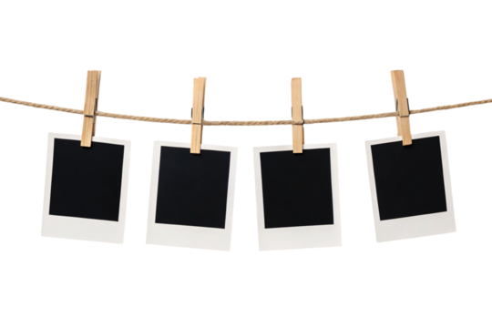 Four blank polaroid photos hanging on rope with wooden clothespins against white background, isolated on a transparent background