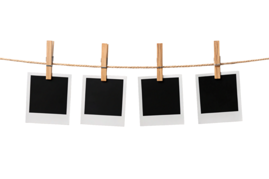 Four empty instant camera photos clipped to twine rope with natural wood clothespins, isolated on a transparent background