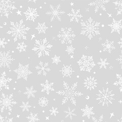 Christmas seamless pattern with big and small snowflakes in various designs, white on gray background.
