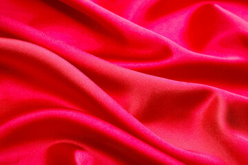 Vibrant red satin fabric with smooth, flowing folds and a glossy sheen. Ideal for fashion design, luxury branding, romantic themes, and elegant creative visuals.