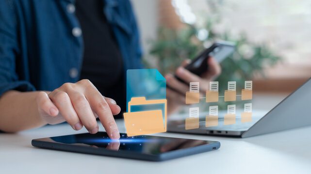 Close-up of woman managing digital folders on tablet with mobile phone and laptop nearby, showing cloud file sharing across devices, modern business technology concept. - Powered by Adobe