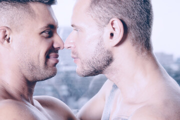 Fototapeta premium Young attractive gay couple kissing and hugging. Romantic relationship on honeymoon.