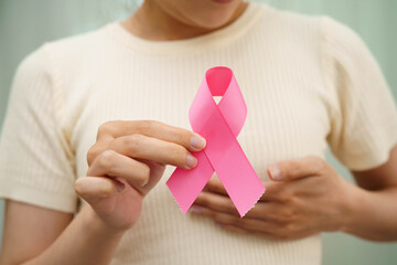 Asian woman with pink ribbon for October world breast cancer day.