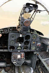 Detailed View of an Abandoned Aircraft Cockpit Featuring Worn Instrument Panel and Control Systems...