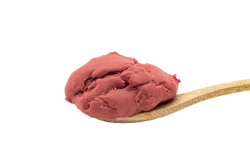 a scoop of red ice cream on a wooden spoon