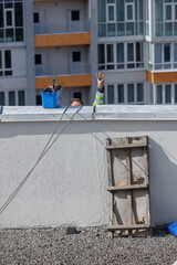 A Unique Perspective on Construction Life Featuring a Worker s Hand Showing a Peace Sign Over a Building Rooftop with Tools and Scenery in the Background