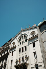 Elegant white Art Nouveau building in Belgrade with decorative facade and sculptural details, seen from street level.