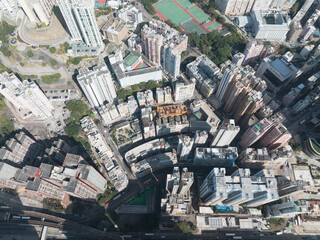 Jan 11, 2022 - Hong Kong, China: Aerial view of Hong Kong cityscape with tall buildings, roads, and green spaces near Victoria Harbor.
