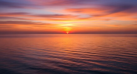 Obraz premium Majestic sunrise over the tranquil sea, illuminating the sky with vibrant hues and creating a