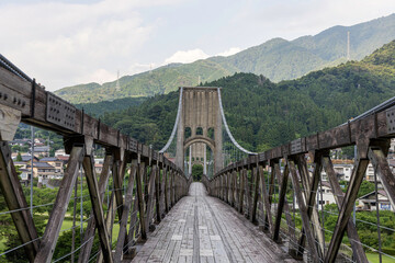 Fototapeta premium 歴史的な木造吊り橋と山の風景が美しい長野県の桃介橋
