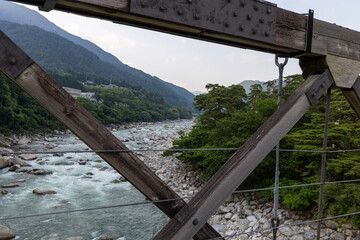 Fototapeta premium 長野県南木曽町に架かる歴史的な吊り橋桃介橋から望む家