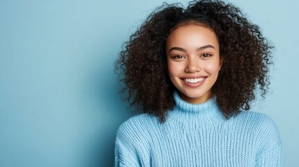 Young woman smiles brightly in a light-blue sweater