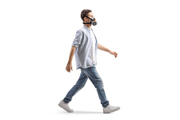 Full length profile shot of a man walking and wearing anti pollution mask
