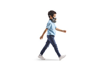 Full length profile shot of a boy walking with anti pollution mask