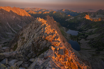 Aerial view of the jagged peaks catching the early morning light, casting shadows across the valleys and revealing the tranquil lakes nestled below, VysokÃ© Tatry, PreÅ¡ov Region, Slovakia.