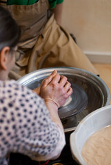 Close-up of hands molding clay on potter’s wheel 