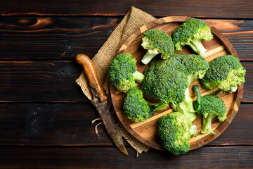 Organic broccoli in a wooden bowl, ready to cook. Close-up. Rustic style.